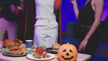 A group of people standing around a table with food video