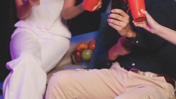 A group of people holding red cups while sitting on a couch video