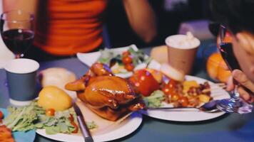 A group of people sitting at a table with plates of food video