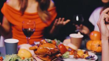 A group of people sitting at a table with food and drinks video