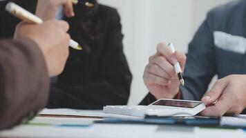 Business people working on a document with a calculator video