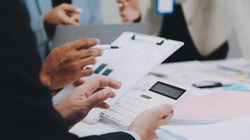 Business people working on a document with a calculator video