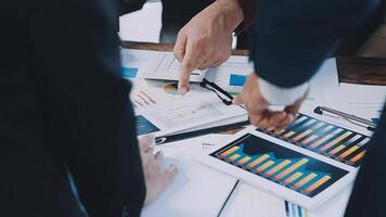 Business people working on a table with graphs and papers video