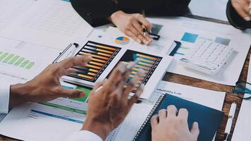 Business people working on a laptop with graphs and papers video