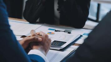 Business people sitting at a table with papers and pens video