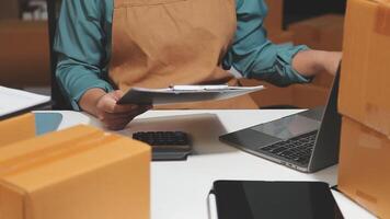 A woman is working on her laptop while surrounded by boxes video