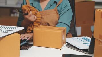 A woman is working on her laptop while sitting at a desk with boxes video