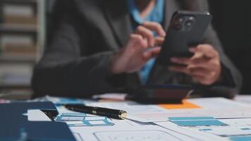 A person in a suit is using a cell phone on a desk video