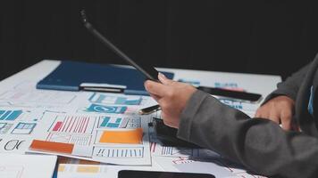 A person in a suit sitting at a table with a tablet and papers video