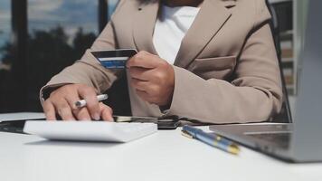 A woman in a business suit is holding a credit card video