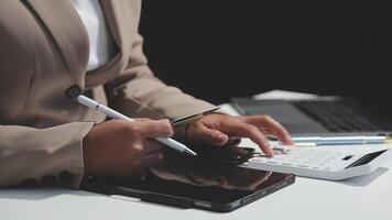 A person in a suit is using a calculator and pen video
