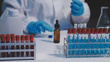 A person in a lab coat is holding a test tube video