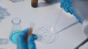 A person in a lab coat is holding a test tube video