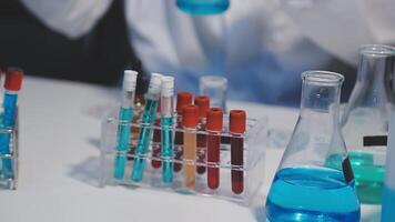 A person in a lab coat is holding a test tube video
