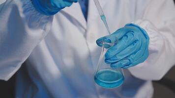 A person in a lab coat holding a test tube video