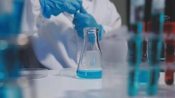 A person in a lab coat is working on a test tube video