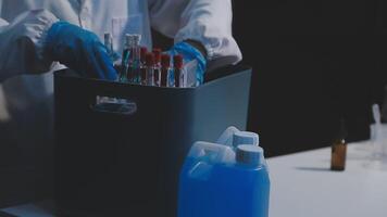 A person in a lab coat holding a container with some liquid video