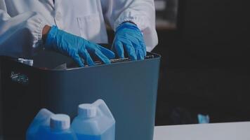 A person in a lab coat is holding a trash can video