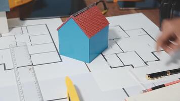 A person is working on a house plan with a ruler and pencils video
