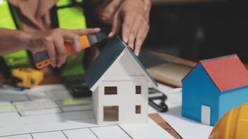 A person is working on a model of a house video