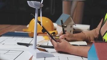 A person is working on a project with a wind turbine video