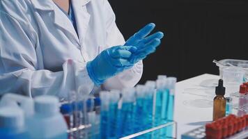 A person in a lab coat is holding a test tube video