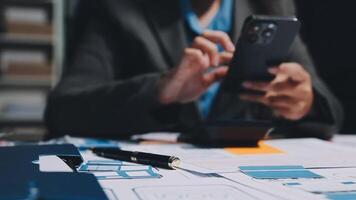 A person in a suit is using a cell phone on a desk video