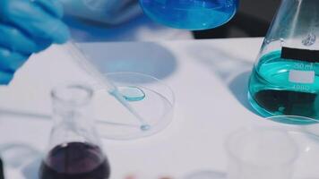 A person in a lab coat is holding a test tube video