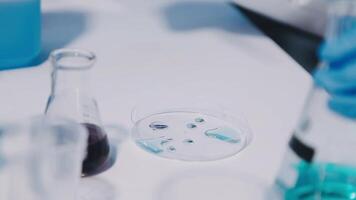 A person in a lab coat is holding a test tube video