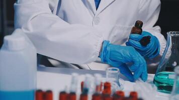 A person in a lab coat is holding a test tube video
