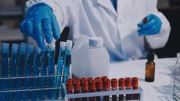 A person in a lab coat is holding a tube of blood video