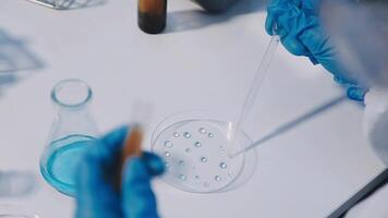 A person in a lab coat is holding a test tube video