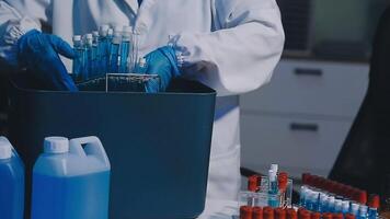 A man in a lab coat is holding a container with blue liquid video