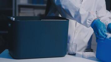 A person in a lab coat is holding a container video