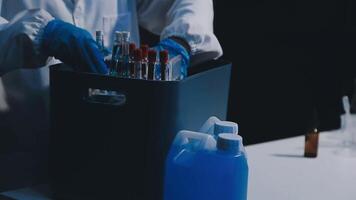 A person in a lab coat is holding a container with some liquid video