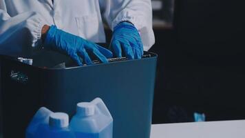A person in a lab coat is holding a trash can video