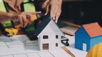 A person is working on a model house with a hammer and a screwdriver video