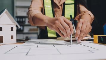 A person is working on a blueprint with a house and a car video
