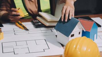 A person is working on a house model with a hardhat video