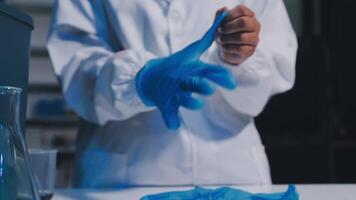 A person in a lab coat is holding a blue glove video
