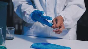 A person in a lab coat is holding a blue glove video