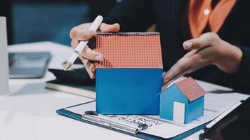 A person is holding a house model on a desk video