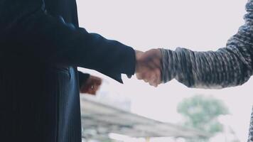 Two people shaking hands in front of a building video