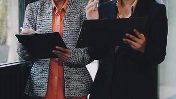 Two business women standing next to each other with their laptops video