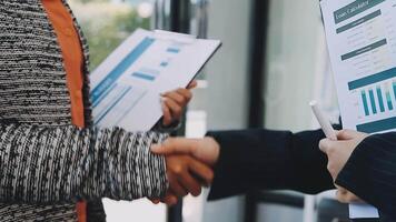 Two business people shaking hands with papers in front of them video