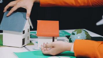 A person is holding a model house on a table video