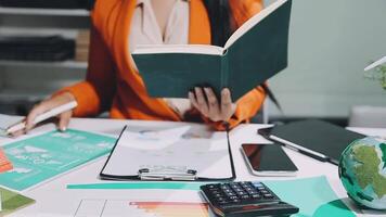 Woman working at desk with laptop and books video