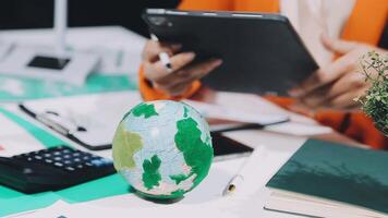 Businesswoman using tablet computer and globe on desk video