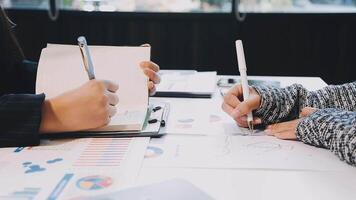 Two people working on a paper with a pen and paper video