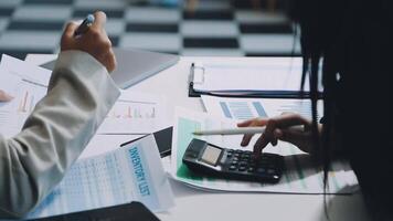 Two people at a table with papers and a calculator video